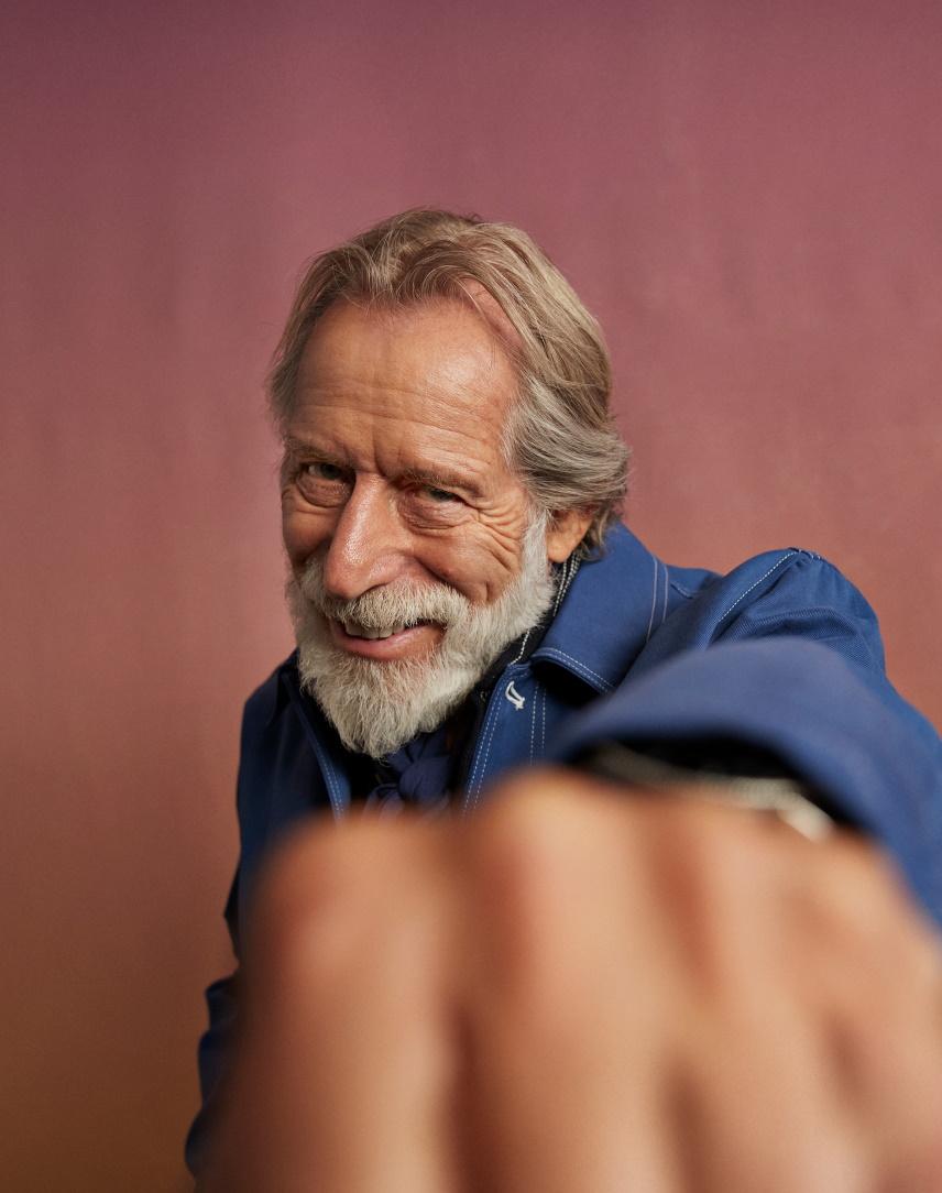 Älterer Herr mit Bart streckt Faust in Richtung der Kamera.