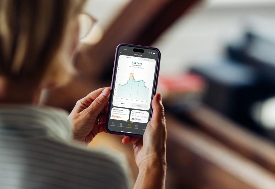 Frau schaut auf ihrem Smartphone Informationen zu einem dynamischen Stromtarif an