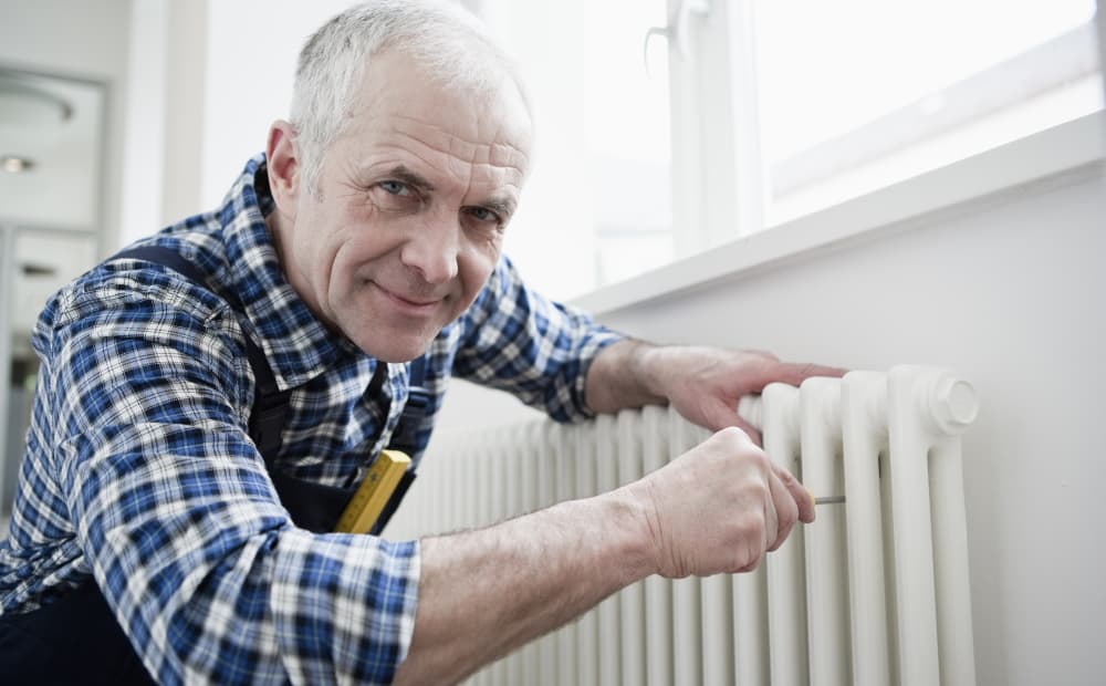 Ein erfahrener Handwerker repariert eine Heizung